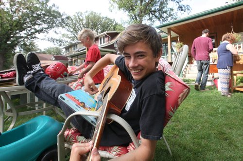 Fifteen year old Myles Ross and his little brother Winston - 11-years-old, try to strum up business at their family Garage Sale Saturday at 103 Borebank street before they move to the east coast.  Long weekends throughout the summer are a popular time for garage sales in Manitoba. Standup photo.  Aug 02, 2014 Ruth Bonneville / Winnipeg Free Press