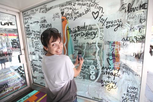 Local artist Kal Barteski takes a selfie in the glassed in window space provided by the Women's Health Clinic on Graham Ave that  artist Barteski created to promote positive body image messages.  See story.   Aug 02, 2014 Ruth Bonneville / Winnipeg Free Press