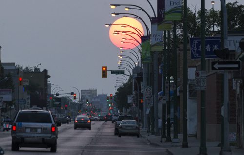 The sun sets just before 9:00pm on Saturday evening along Notre Dame Avenue. Sarah Taylor / Winnipeg Free Press August 2, 2014