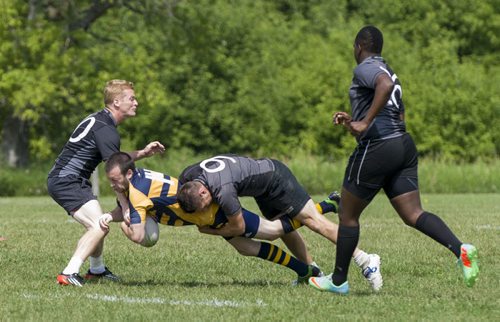 140803 Winnipeg - DAVID LIPNOWSKI / WINNIPEG FREE PRESS  Josh Fisher of the Saracens team gets tackled by the Highlanders during SNAFU 44 Rugby Tournament at Maple Grove Rugby Park  Sunday August 3, 2014.