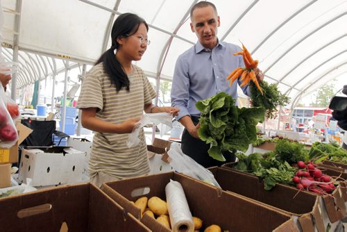 LOCAL - St. Norbert Farmers Market gets a boost from the government to improve their facilities at the popular market. Market farmer Ming Zhai and NDP Kevin Chief pose for some photos in the market . BORIS MINKEVICH / WINNIPEG FREE PRESS  August 6, 2014