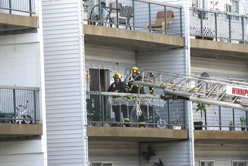 Residents were evacuated from the Adsum Square Apartments on Adsum Drive Friday after a possible lightning strike to the building.Fire Fighters on a second floor balcony.   Wayne Glowacki/Winnipeg Free Press August 8 2014