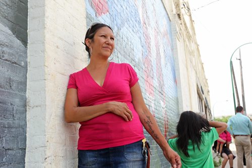 Althea Guiboche, also known as the Bannock Lady, stands near the corner where she hands out free bannock  weekly (Dufferin & Main) with her children after talking to the media about her views on the recent Facebook posting scandal.  WIth her son Justin (6yrs). See story.   Aug 09, 2014 Ruth Bonneville / Winnipeg Free Press