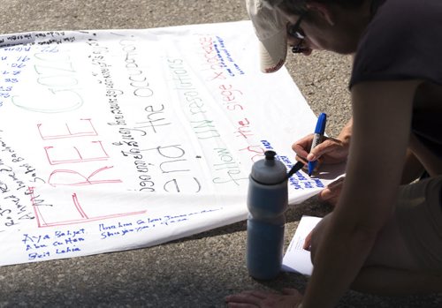 Supporters write the names of those who have died in Gaza at the Legislative Building on Saturday. The list has been updated at each rally after more and more have been killed. Winnipeg has held four rallies for Gaza in the past three weeks. Sarah Taylor / Winnipeg Free Press August 9, 2014
