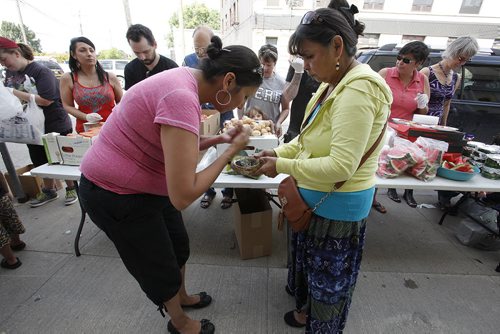 August 10, 2014 - 140810  -  Althea Guiboche (L), The Bannock Lady, goes through a smudging ceremony with Gerry Shingoose prior to her and volunteers distributing food and clothing to local people on Dufferin at Main Sunday, August 10, 2014. Guiboche invited Gord Steeves and his wife Lorrie to volunteer after Lorrie's comments regarding homeless men in Winnipeg's downtown surfaced. The mayoral hopeful and his wife did not show up. John Woods / Winnipeg Free Press