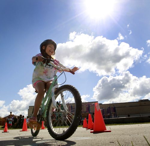 Kierra,8, rides a bicycle through a safety course during the Cycle Safely Bike Rodeo held Monday at Elwick Community School. She was one of about forty children who took part in the event presented by the Manitoba Public Insurance that provided the children a fun riding lesson on the rules of the road, traffic signs and bicycle helmets.   Wayne Glowacki/Winnipeg Free Press August 11 2014
