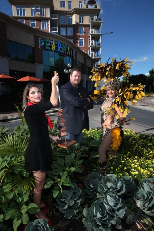 CARNIVAL owner Noel Bernier (center) poses with Samba dancer Marcia Monteggia and Renata Serrano who brandishes a Picanha, Brazilian cut BBQ beef.  This is for a Intersection profile piece on Bernier, restaurateur, timed around the Carnaval Festival Aug 22 - 23, a Latin-flavoured street fest that shuts down Bannatyne. August 11, 2014 - (Phil Hossack / Winnipeg Free Press)