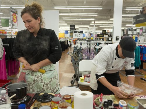 Former Top Chef contestant Heather Porteous and chef and food services manager at Siloam Mission Chris Buffington participates in a cooking competition held by Walmart and Canadian Red Cross on Thursday. Sarah Taylor / Winnipeg Free Press August 14, 2014