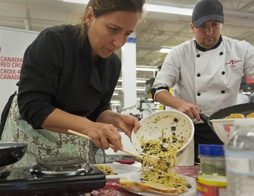 Former Top Chef contestant Heather Porteous and chef and food services manager at Siloam Mission Chris Buffington participates in a cooking competition held by Walmart and Canadian Red Cross on Thursday. Sarah Taylor / Winnipeg Free Press August 14, 2014