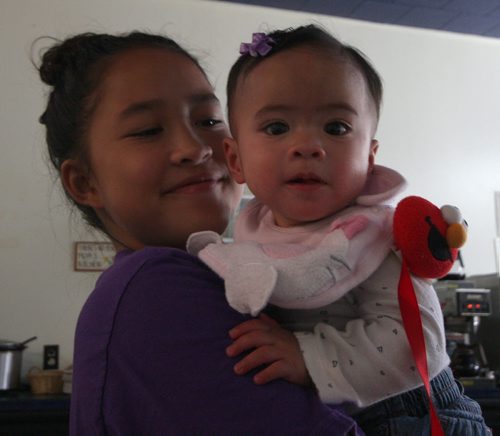 Zachi Espayos holds her sister Zoey at Mom's Kitchen in Hamiota. Zachi is set to donate bone marrow to her twin sisters who suffer from a rare blood disorder.  (Charles Tweed/Brandon Sun)