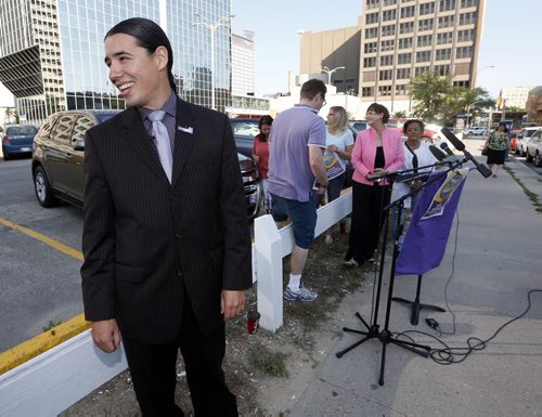 A relaxed Robert Falcon Ouellette  shares laugh with reporter after picking up trash that turned out to be the reporters  coffee cup  before he made his announcement on  surface parking in the downtown Friday morning - story by kevin rollason  Aug 15 2014 / KEN GIGLIOTTI / WINNIPEG FREE PRESS