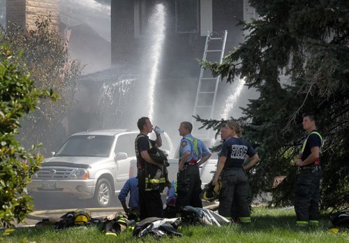 Firefighters and equipment sweat it out fighting a blaze that started at 54  Nichols ave Friday afternoon, two homes went up in flames. Crews battled the fire as well as extreme heat. See story. August 15, 2014 - (Phil Hossack / Winnipeg Free Press)