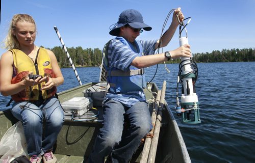 At right, Matthew Fogel, a grade 12 student at St. John's-Ravenscourt with Soleil Grise , a University of Waterloo science student gets ready to lower an instrument called a RBR to measure the temperature and oxygen levels at different depths in Lake # 373. Matthew is part of a school pilot project in the  Experimental Lakes Area (ELA) located past Kenora in Northwestern Ontario. Nick Martin story Wayne Glowacki/Winnipeg Free Press August 14 2014