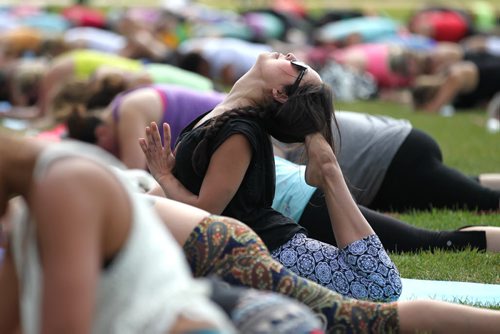 ALL-DAY YOGA - Teresa Daniels does the King Pidgeon yoga pose while participating in one of the largest outdoor yoga and music festivals  at the Scotia Bank Stage at the Forks Saturday. All 3 Moksha Yoga Studios shut their studio doors for the entire day to take things outdoors. Standup photo  Aug 13, 2014 Ruth Bonneville / Winnipeg Free Press
