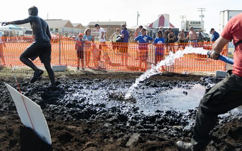 Stephen Dyck runs through mud mayhem, the final obstacle of the Mud Run at Springhill Winter Sports Park and Oasis Resort on Saturday. Sarah Taylor / Winnipeg Free Press August 16, 2014