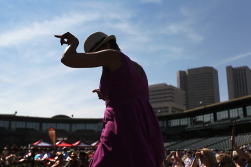Joy Stadnichuk is silhouetted against Wpg's skyline as she dances to the music of the local band The Perpetrators, nominated for the Western Canadian Music Award for Blues Recording of the Year; at the  3rd Annual Winnipeg BBQ & Blues Festival at Shaw Park Saturday.   The festival takes place August 16th and 17th, and will feature the best in international, national and local blues performers along with the Winnipeg Free Press Pit Masters barbeque competition.  Picture page of photos  Aug 13, 2014 Ruth Bonneville / Winnipeg Free Press