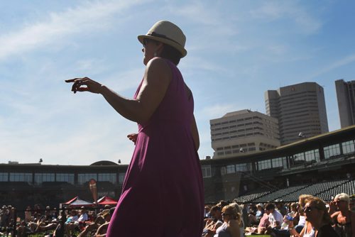 Joy Stadnichuk is silhouetted against Wpg's skyline as she dances to the music of the local band The Perpetrators, nominated for the Western Canadian Music Award for Blues Recording of the Year; at the  3rd Annual Winnipeg BBQ & Blues Festival at Shaw Park Saturday.   The festival takes place August 16th and 17th, and will feature the best in international, national and local blues performers along with the Winnipeg Free Press Pit Masters barbeque competition.  Picture page of photos  Aug 13, 2014 Ruth Bonneville / Winnipeg Free Press