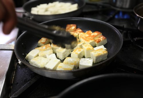 49.8 Feature Chef Rob Thomas Frying paneer to go with second course - Beet salad with dandelion greens, fried paneer, candied pecans & roasted tomato vinaigrette.  Aug 20, 2014 Ruth Bonneville / Winnipeg Free Press