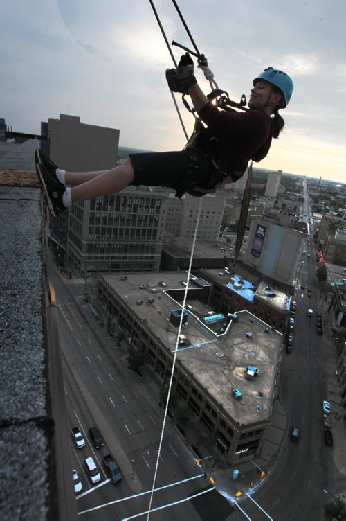 Janice Bamforth with Vertical Adventures, steps onto the edge of the RBC Building, Wednesday evening just before rappelling down the 200 feet as part of the set up crew doing trial runs for tomorrows Drop Zone event which raises money for Easter Seals SMD Foundation.    Standup photo  Aug 20, 2014 Ruth Bonneville / Winnipeg Free Press