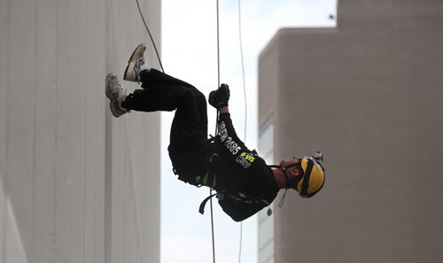 Warren Herntier flips upside down as he nears the bottom of the RBC building after rappelling 200 feet during the annual Easter Seals Drop Zone event.  Money raised in the the fundraising event  goes to Manitoban's living with disabilities. (SMD Foundation)  Standup photo  Aug 21, 2014 Ruth Bonneville / Winnipeg Free Press