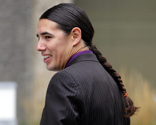 Robert-Falcon Ouellette  , mayoral candidate  aboriginal heritage is always on display , was out side of the new ly constructed Police HQ's , talks about the cost over run and RCMP investigation .  Aug 22 2014 / KEN GIGLIOTTI / WINNIPEG FREE PRESS