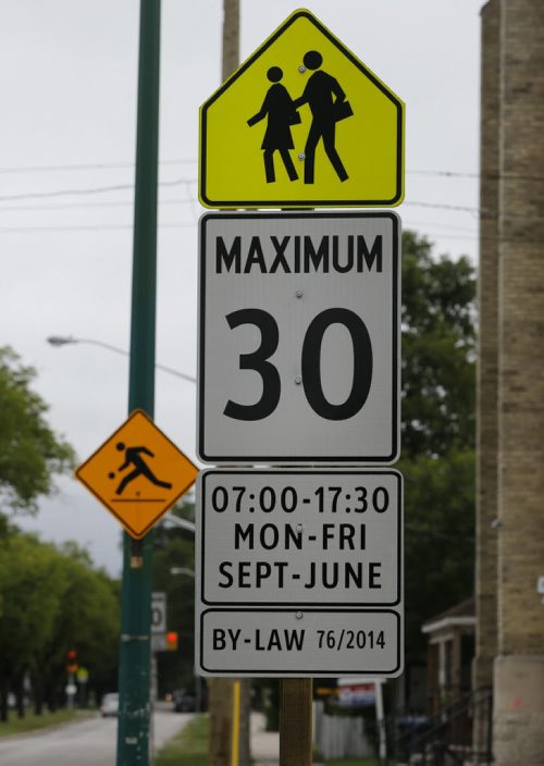 STDUP .School Zone signage is popping up  all over the city in preparation  for the new school year . The Yellow  symbol  sign of children walking  , plus a second sign  indicating lowered  speed  area to 30k/Hr  a third sigh denotes the city by-law  number all on the same post . An older  orange kids playing is also  still in service . Located at McKenzie St. on Burrows Ave.  Aug 22 2014 / KEN GIGLIOTTI / WINNIPEG FREE PRESS