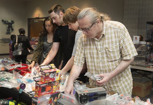Larry Sutherland (far right), Ryan Edwards, Justin Lavallee and Marilyn Chong admire the hundreds of collectors items at Manitoba's first Transformers themed fan convention on Saturday at the Clarion Hotel. Sarah Taylor / Winnipeg Free Press August 23, 2014