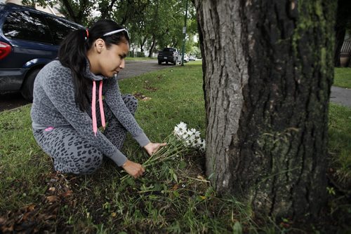 August 24, 2014 - 140824  -  On Sunday, August 24, 2014 Sonja Eaglestick, 21, places flowers on Spence St where she found Helder Serpa who was stabbed to death Saturday. John Woods / Winnipeg Free Press