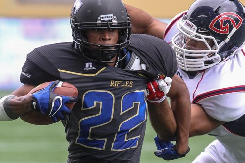 Winnipeg Rifles' Victor St. Pierre-Lavoile (22) runs the ball while Calgary Colts' Tariq LaChance (72) tries to pull him down during a game at Investors Group Field Sunday afternoon.  140824 - Sunday, August 24, 2014 -  (MIKE DEAL / WINNIPEG FREE PRESS)