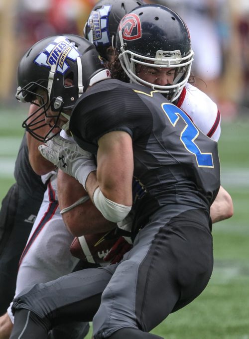 Winnipeg Rifles' Braedy Will (24) strips the ball from Calgary Colts QB Cam Fox (5) while Rifles' Brady Carter (56) completes the tackle during a game against the Calgary Colts at Investors Group Field Sunday afternoon.  140824 - Sunday, August 24, 2014 -  (MIKE DEAL / WINNIPEG FREE PRESS)