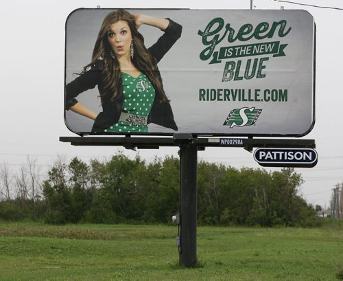 Stdup- Riderville bill board located in Wpg featuring a woman wearing a poke-a-dot Rider green dress with Roughrider  logo ,as some sort of a taunt but the joke is on Sask RR RR , the billboard is in an obscure low traffic  part of Wpg occupied mostly by trucking and  construction firms with the street cut in half due to major   road construction  construction  , located  on Plessis Rd north of Fermor as well the sign can only be seen on one side of the billboard  by southbound traffic .  Aug 25 2014 / KEN GIGLIOTTI / WINNIPEG FREE PRESS