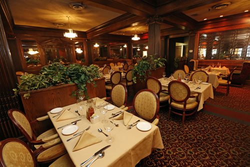 THIS CITY - 2nd floor main dining room  of Bailey's Restaurant & Lounge with  Leo Groumoutis (owner) : This is for a Sunday This City profile of Bailey's - a downtown institution since the early 70s. Owner Leo Groumoutis started there as a 13-year-old dishwasher and, a couple of decades later, ended up buying the place together with his brother George.  So shots of Leo - maybe holding up one of Bailey's signature dishes (they make a killer steak sandwich) - in one of the restaurant's dining rooms. We'll have room for five or six pics so also shots of the exterior - the lounge & pool table area, the library room - and if possible, there are a series of hidden tunnels in the basement that lead throughout the downtown - Leo used to play hide and seek down there as a kid, so that might be an interesting pic, too....story by Dave Sanderson .Aug 26 2014 / KEN GIGLIOTTI / WINNIPEG FREE PRESS