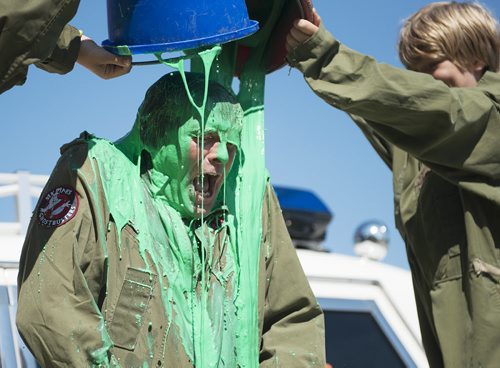 James Thevenot gets a bucket of green slime and ice dumped on him by his kids Tessa and Thomas at Six Pines Haunted Attractions on Wednesday. Sarah Taylor / Winnipeg Free Press August 27, 2014
