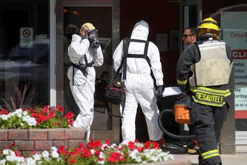 Haz-Mat garbed firefighters enter the Canadian Blood Services building on Willam ave Thursday afternoon. THe building was evacuated for about 2 hrs while something was cleaned up inside. See story. August 28, 2014 - (Phil Hossack / Winnipeg Free Press)