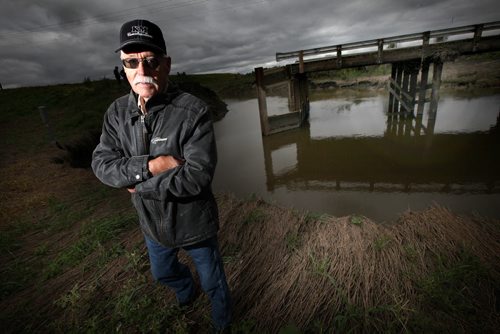 Water Woes.....Municipal Reeve Ralph Wang poses in front of a washed out Bridge over a creek near Pierson Mb. Unusual rainfall patterns and uncontrolled drainage has left most fields in the area unproductive this season and some for multiple seasons. Roads and bridges have also been washed out. See Larry Kusch story. August 25, 2014 - (Phil Hossack / Winnipeg Free Press)