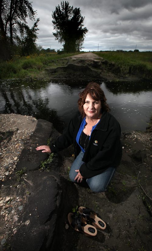 Water Woes.....Municipal Counsellor Debbie McMechan poses in front of a washed out municipal road near Pierson Mb. Unusual rainfall patterns and uncontrolled drainage has left most fields in the area unproductive this season and some for multiple seasons. Roads and bridges have also been washed out. See Larry Kusch story. August 25, 2014 - (Phil Hossack / Winnipeg Free Press)