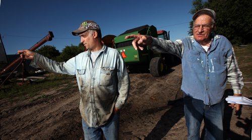 Terry (left) and Art Shuddemat both point out the Souris River which at half a mile wide covers over 400 acres of productive farmland on their farm near Melita. Unusual rain patterns and drainage issues from Saskatchewan and Manitoba farmers have created agricultural and Municipal headaches.  See Larry Kusch story. August 26, 2014 - (Phil Hossack / Winnipeg Free Press)