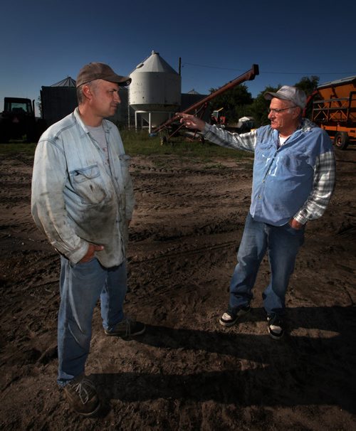Terry (left) shrugs while his father Art Shuddemat points out the Souris River which at half a mile wide covers over 400 acres of productive farmland on their farm near Melita. Unusual rain patterns and drainage issues from Saskatchewan and Manitoba farmers have created agricultural and Municipal headaches.  See Larry Kusch story. August 26, 2014 - (Phil Hossack / Winnipeg Free Press)