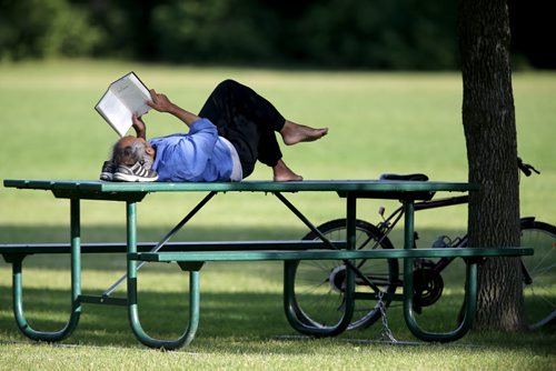 Assan Alizadeh rinds a spot to read in St.Vital Park, Thursday, August 28, 2014. (TREVOR HAGAN/WINNIPEG FREE PRESS)