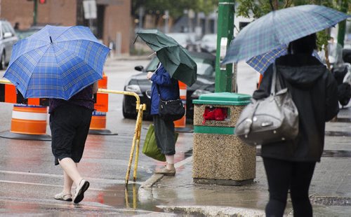 People bring out there umbrellas on a wet Friday morning on St. Mary's Avenue. Sarah Taylor / Winnipeg Free Press August 29, 2014