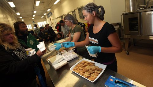 Reese Precourt hands out cookies to patrons Friday at the Lighthouse Mission's soup kitchen. Precourt baked cookies towards the kitchen's renovations. See Ashely Prest story.  August 29, 2014 - (Phil Hossack / Winnipeg Free Press)