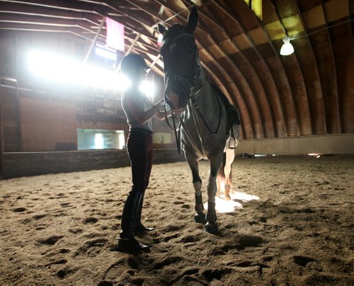 Katherine Page  uses the dry, indoor barn at Teske's Farm to ride and brush down her twelve-year-old horse- Chaos Saturday morning after her farm in Headingley was flooded in Friday evenings downpour.    Standup photo     Aug 30, 2014 Ruth Bonneville / Winnipeg Free Press   Ruth Bonnevilles