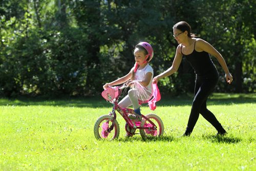 Six-year-old Amara Dumont, with the help of her mom Jamie, learns to ride her bike for the 1st time without training wheels in a park off Lanark Street Saturday.   Standup photo     Aug 30, 2014 Ruth Bonneville / Winnipeg Free Press   Ruth Bonnevilles