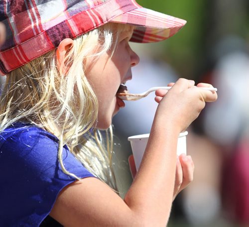 Five-year-old Coralie Sabourin-Anna,  eats her ice-cream while watching The Contemporary Dancers perform on the  waterfront at the Forks Saturday during the PRAIRIE BARGE FESTIVAL - Manitoba and Saskatchewan artists team up for three days of music, art and culture showcasing the diverse talent of the Prairies.    Aug 30, 2014 Ruth Bonneville / Winnipeg Free Press   Ruth Bonnevilles