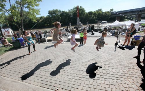 People gather along the waterfront at the Forks Saturday to play games and watch performances during the PRAIRIE BARGE FESTIVAL - Manitoba and Saskatchewan artists team up for three days of music, art and culture showcasing the diverse talent of the Prairies.    Aug 30, 2014 Ruth Bonneville / Winnipeg Free Press   Ruth Bonnevilles