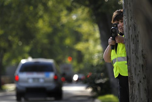 Winnipeg Police Const. Karen McCowan watches for motorists on McDermot Ave. execeding the 30km. speed zone near Ecole Sacre Coeur School Tuesday morning. Most of the drivers were given warnings to try to educate the motorists of the new school zone speeds that took effect Sept.1 7A.M.-5:30P.M.    Wayne Glowacki/Winnipeg Free Press Sept.2 2014
