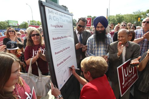 Mayoral candidate Judy Wasylycia-Leis    signs her four point pledge outside her campaign office on Portage Ave Tuesday afternoon after her announcement today- Standup Photo- Sept 02, 2014   (JOE BRYKSA / WINNIPEG FREE PRESS)