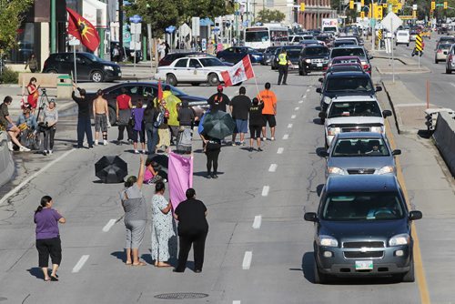 September 2, 2014 - 140902  -  People block two lanes of rush-hour traffic on Portage Ave at Strathcona St in Winnipeg Tuesday, September 2, 2014.  John Woods / Winnipeg Free Press
