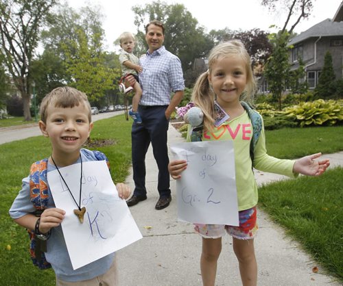 Tuesday was the first day of school for Isaak,4, going into kindergarten and his sister Ava,6, starting grade 2 and they have the paperwork as they prepare to go to Robert H. Smith School with their dad Kirk Johnson holding younger brother Oliver. Wayne Glowacki/Winnipeg Free Press Sept.3 2014