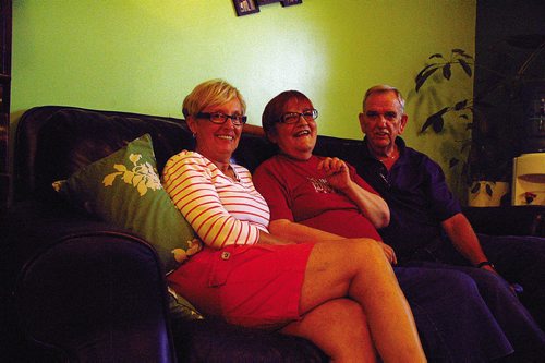 Canstar Community News Aug. 18/14 - LArche Winnipeg member Nicole Delaquis (centre) is shown with brother Ron and his wife Janine at the LAîné home in Transcona. (DAN FALLOON/CANSTAR COMMUNITY NEWS/HERALD)